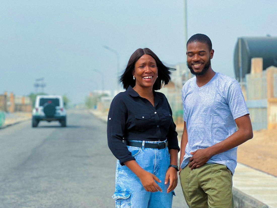 Two young Nigerians smiling on a roadside
